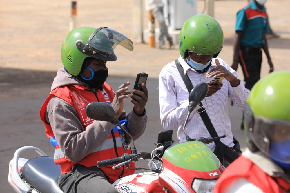 A moto taxi user pays the transport fee via Mobile money in Kigali.Taxi moto fares, using smart meters, have been increased from Rwf 107 per kilometre to Rwf 117, while payment for the first two meters is Rwf 400 . FILE 
