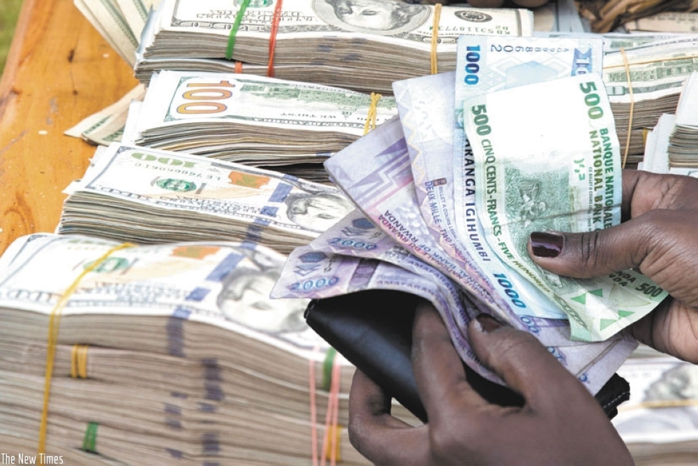 A client counts moneyin a forex bureau in Kigali. Photo: File.