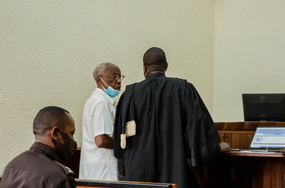Genocide suspect Venant Rutunga consults with his lawyer during his appearance before Kicukiro Primary Court on August 12. He will be back in court on September 19. / File