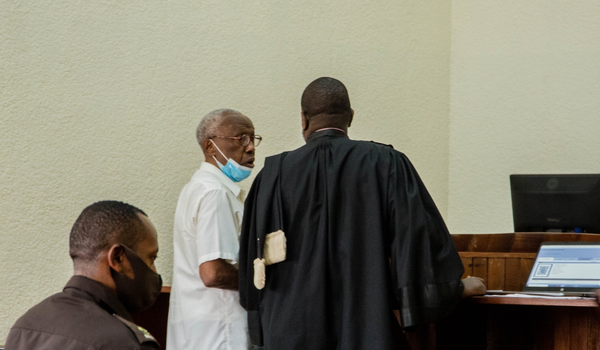 Genocide suspect Venant Rutunga consults with his lawyer during his appearance before Kicukiro Primary Court on August 12. He will be back in court on September 19. / File