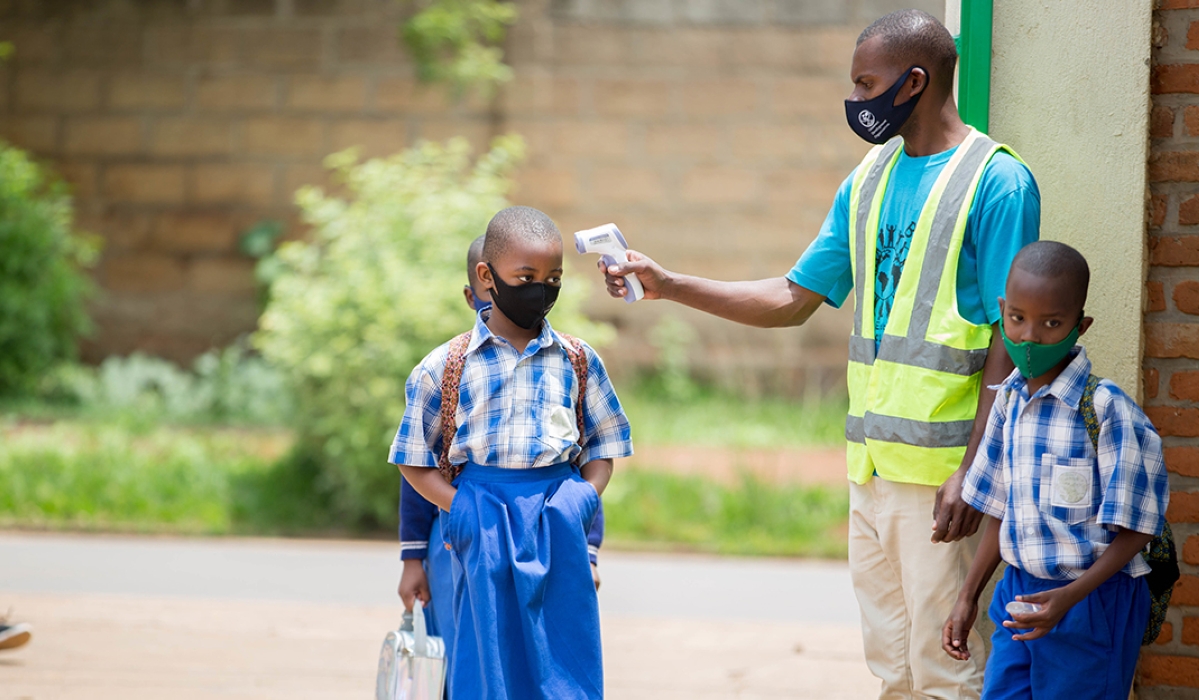 Students undergo temperature screening before entering class at Groupe Scolaire Remera Catholique. Photo: Dan Nsengiyumva.
