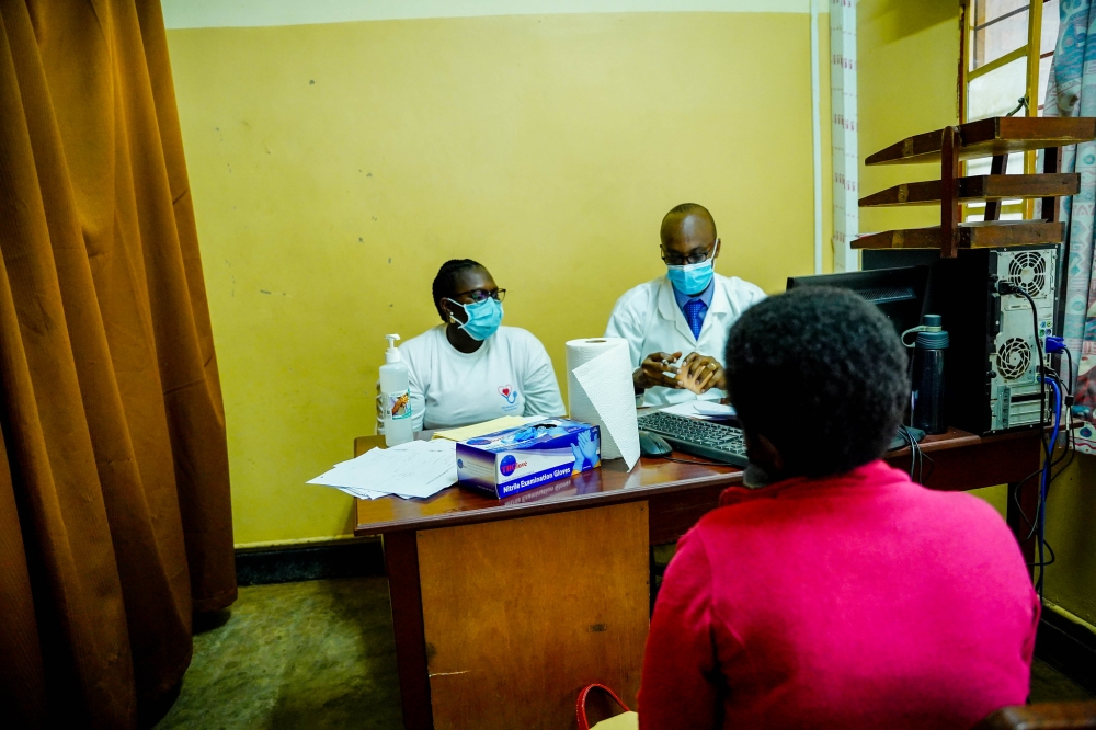 Doctors talk to a patient during consultation. Medics are moving from public hospitals to NGOs to do well paying jobs as consultants and project coordinators. Photo: Dan Nsengiyumva.