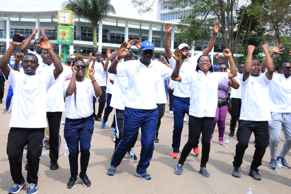 Minister of Health Dr Daniel Ngamije (C) stretching his body with other participants during  the mass sports exercise that raised awareness on Breast Cancer on Sunday . Craish Bahizi