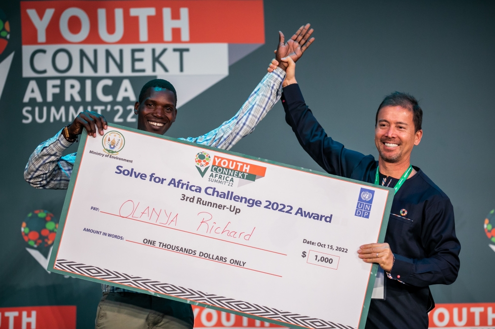Olanya Richard from Uganda receives his cheque of 1000$ at the conclusion of the 2022 Youth Connect Summit in Kigali on October 15. Olanya is among youths who shared what they learnt at the Summit. Olivier M