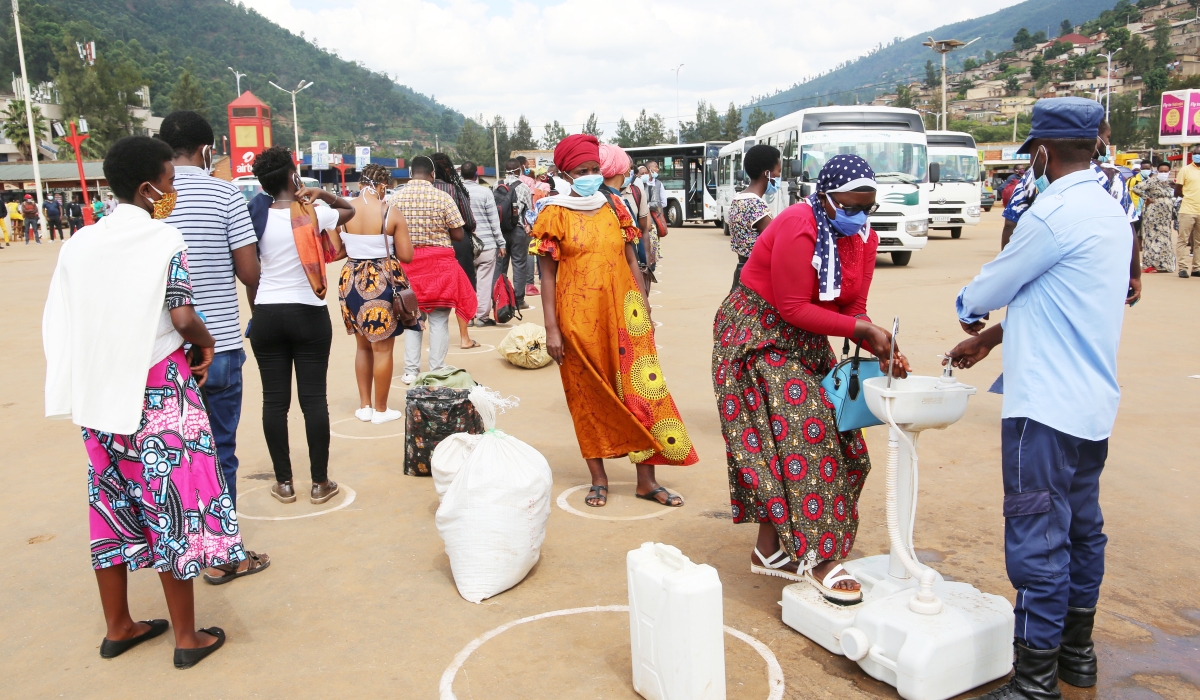 Commuters wash their hands before boarding bus at Nyabugogo taxi bus in 2020. Photo: Craish Bahizi.
