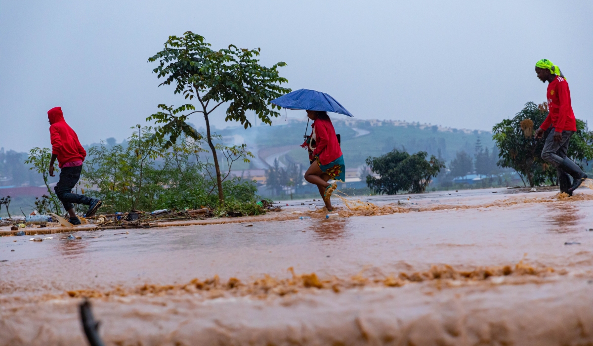 People wade through a flooded street in Kigali. METEO alerted tha some parts of Southern and Eastern Provinces have experienced rainfall deficit in the previous period .File