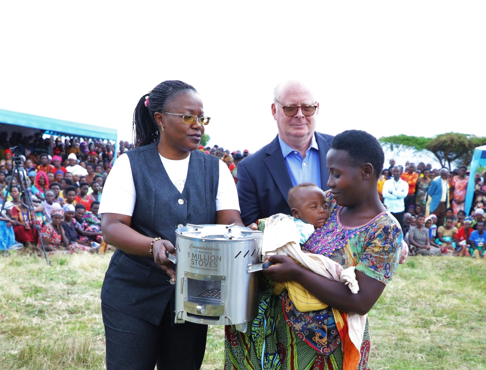 Minister of Environment Jeanne d&#039;Arc Mujawamariya and Neil McDougall, Chairman of DelAgua Group hand over a stove to a resident in Rwamagana District on October 26. All Photos by Craish Bahizi