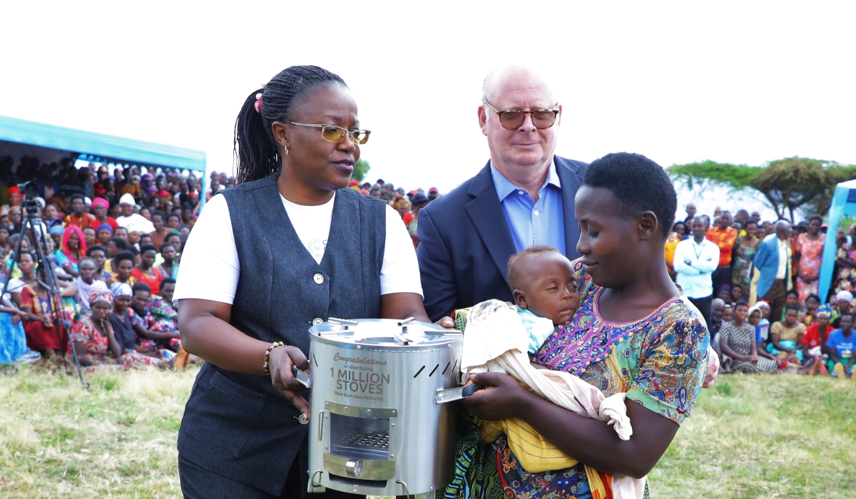 Minister of Environment Jeanne d&#039;Arc Mujawamariya and Neil McDougall, Chairman of DelAgua Group hand over a stove to a resident in Rwamagana District on October 26. All Photos by Craish Bahizi