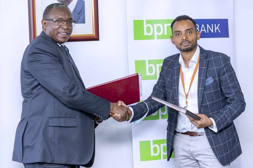 George Odhiambo, the Managing Director of BPR Bank Rwanda Plc (left), shakes hands with Hassan
Adan Hassan, the managing director of ADHI Corporate Group, as they exchange documents after
during the signing ceremony. Photos: Dan Gatsinzi.