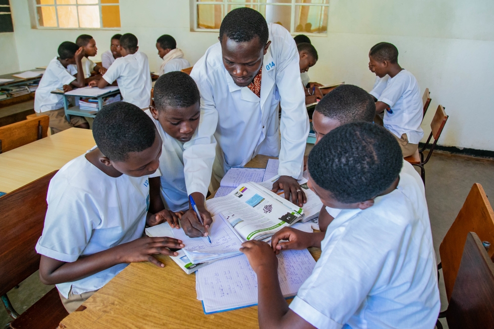 A teacher helps students with group work at  Institut Sainte Famille de Nyamasheke. Teachers play a big role in shaping their students&#039; dreams. File photo.