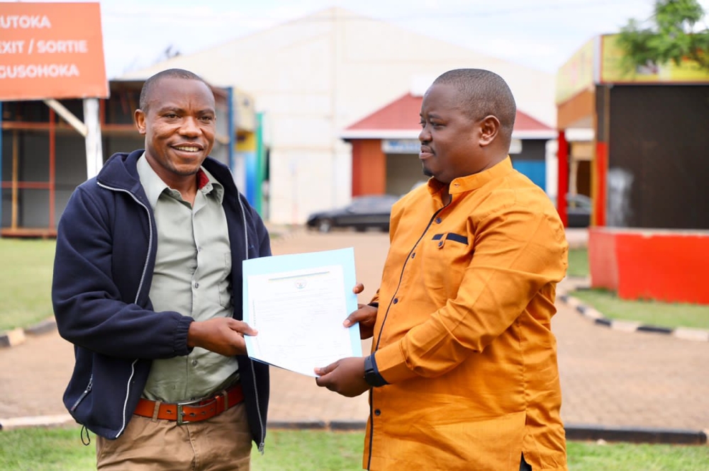 Merard Mpabwanamaguru, City of Kigali’s vice-mayor in charge of urbanisation and infrastructure, hands over land title permit to a resident during a week dedicated to addressing issues related to land transfer. / Courtesy