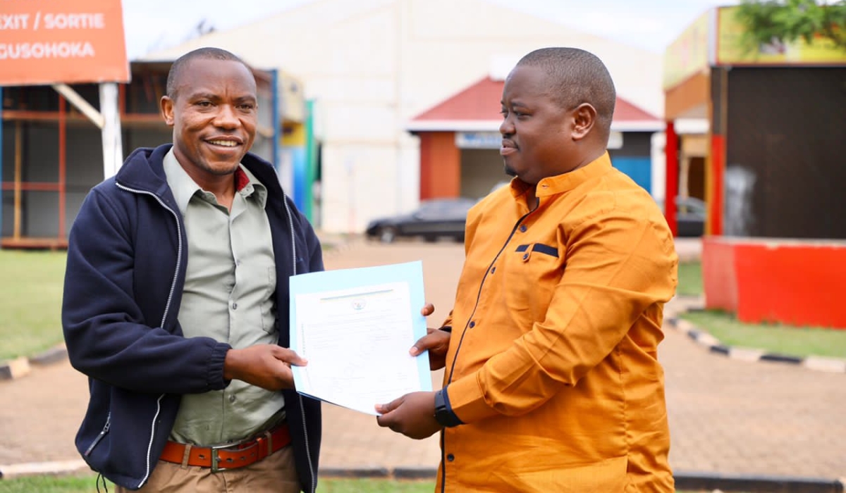 Merard Mpabwanamaguru, City of Kigali’s vice-mayor in charge of urbanisation and infrastructure, hands over land title permit to a resident during a week dedicated to addressing issues related to land transfer. / Courtesy