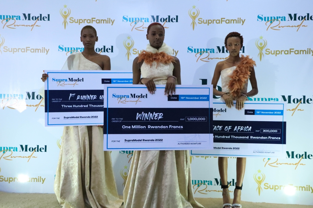 Supra Model 2022 winner Cynthia Semana (C) pose for a cheque of Rwf1,000,000 worth the prize that she won after overcoming
stiff competition from first runner-up Annualite Teresa Rudasingwa (L).