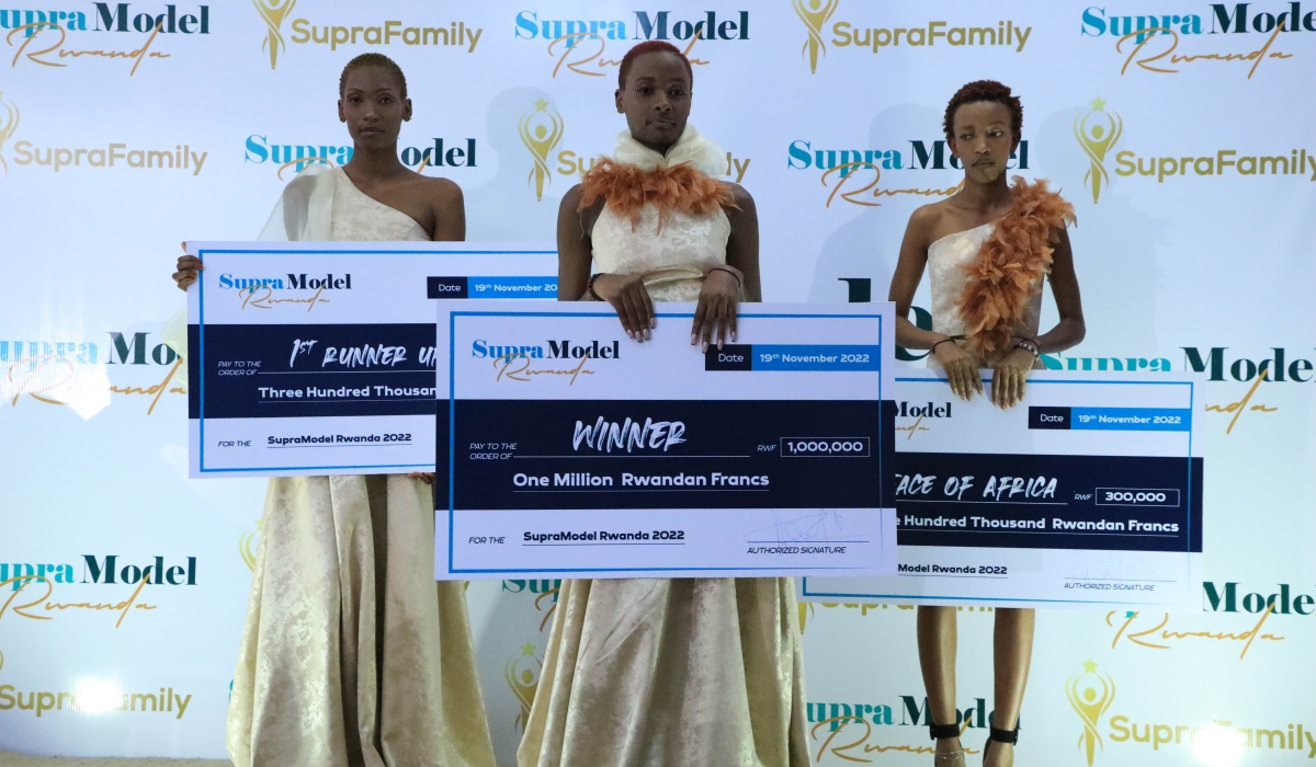 Supra Model 2022 winner Cynthia Semana (C) pose for a cheque of Rwf1,000,000 worth the prize that she won after overcoming
stiff competition from first runner-up Annualite Teresa Rudasingwa (L).