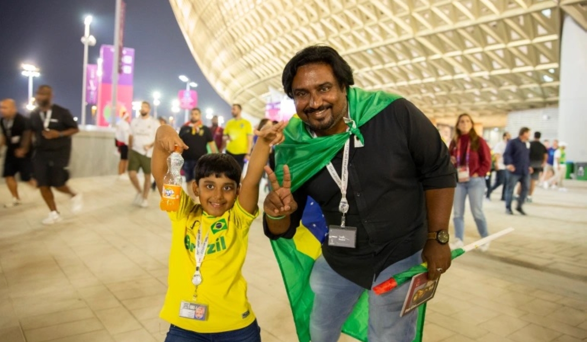 Ashiq and his son at Lusail Stadium cheering for Brazil [Faras Ghani/Al Jazeera]
