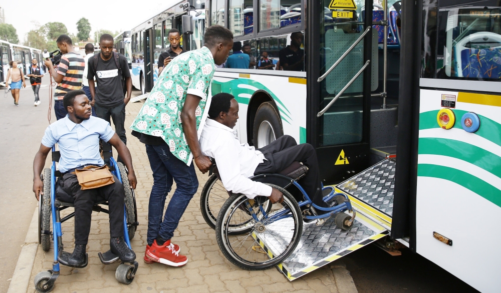 People with disabilities are assisted to board a bus at Kacyiru bus stop on August 30, 2019 . Photo by Craish Bahizi 
