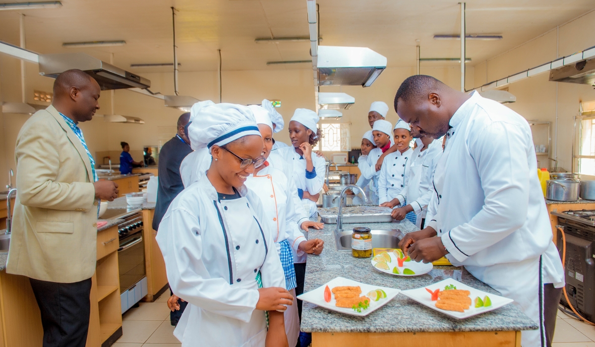 Mount Kenya University Rwanda head of Hospitality and Tourism Management, Paul Okumu (Left)  talks to students during a practical session at the training center in Kigali. Courtesy