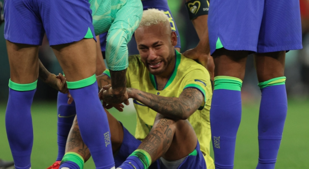 Brazil&#039;s Neymar is consoled by teammates after their quarter-final loss to Croatia at Education City Stadium Doha, on December 9, 2022 [Adrian Dennis/AFP]