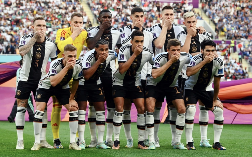 Germany players covered their mouths as they posed for their team group photo before their opening World Cup match against Japan [Annegret Hilse/Reuters]