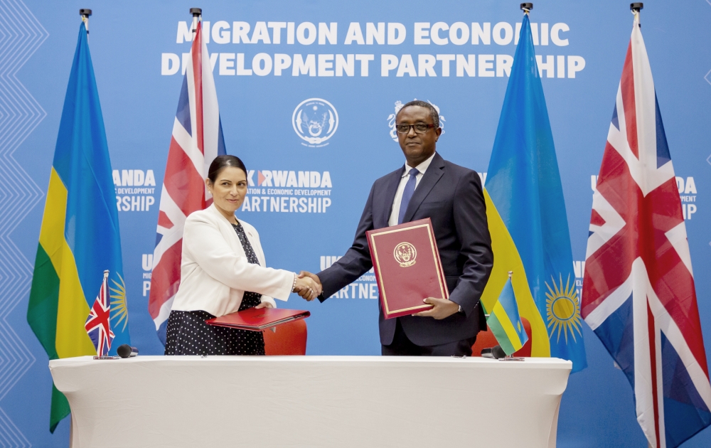 The Minister of Foreign Affairs and International Cooperation Dr. Vincent Biruta and Priti Patel the former Home Secretary of the United Kingdom exchange the documents after signing the deal in Kigali on April 14, 2022.
