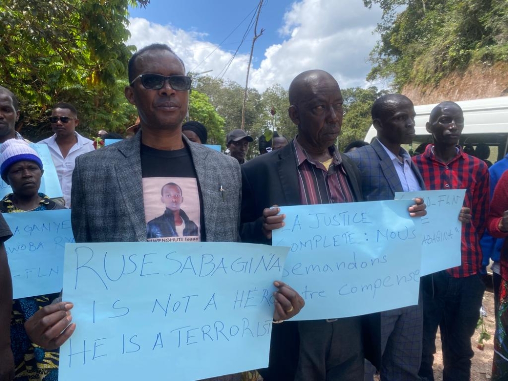 Phenias Karegesa, the father of Isaac Niwenshuti, a 17-year-old boy who was burnt in one of the buses. Seen here with other mourners  during the commemoration event of the victims of the attacks ,on Friday, December 16.
