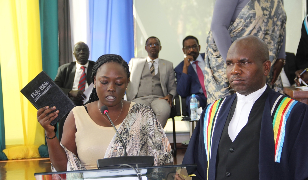 Alodie Iradukunda, the MP representing Rwanda&#039;s youth in EALA, takes oath while holding a bible during the swearing in ceremony in Arusha, Tanzania, Monday, December 19, 2022. Courtesy