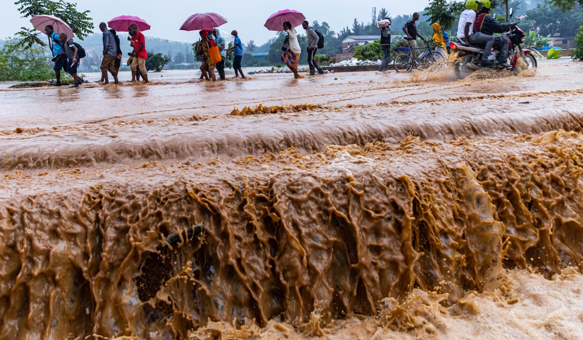 Residents wade through a flooded road at Gakinjiro in Kigali.  File