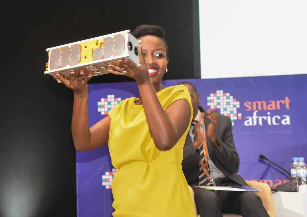Paula Ingabire, the Minister for ICT and Innovation, lifts a prototype of RwaSat-1, the country’s first cube-satellite. File