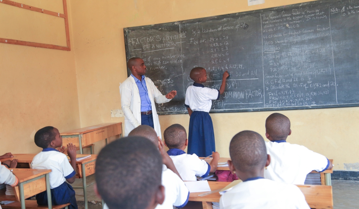 A teacher inspects how a students does an exercise in Kigali. The Teacher&#039;s Day is marked every year on October 5. File