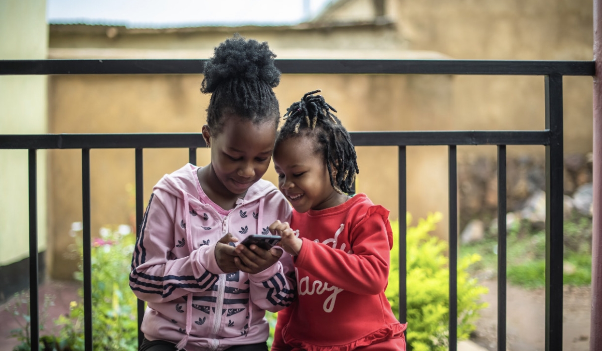 Kase Keza, (L), reads with her little sister. Courtesy photo