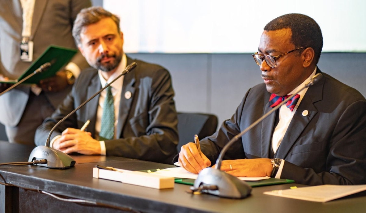 AfDB President Akinwumi Adesina (right) signs a document during the launch of the Mission 1 for 200 in Dakar, Senegal on January 27, 2023. Courtesy