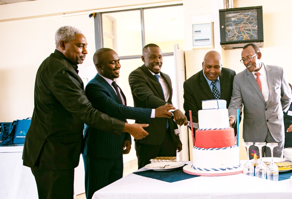 Officials cut a cake at the launch of the memoir titled “Mountain Meets Land of a Thousand Hills&#039; on Friday ,February 10. Photos by Dan Gatsinzi