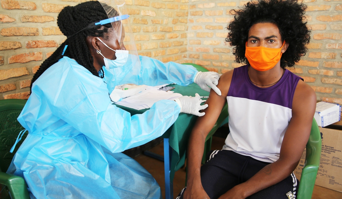 A health worker conducts the Covid 19 vaccination exercise at Gashora transit center in Bugesera District on March 10, 2021 (Craish Bahizi)
