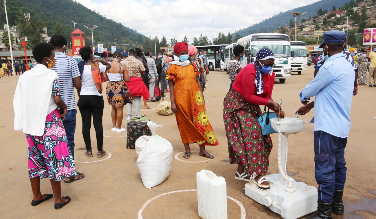 Kigali city residents wash their hands and observe physical distancing  before boarding buses at Nyabugogo taix park as way of curbing the spread of coronavirus on May 4, 2020  .Craish Bahizi