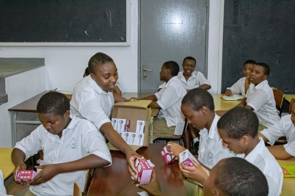 Students receiving sanitary pads donated to them by MKU-Rwanda.