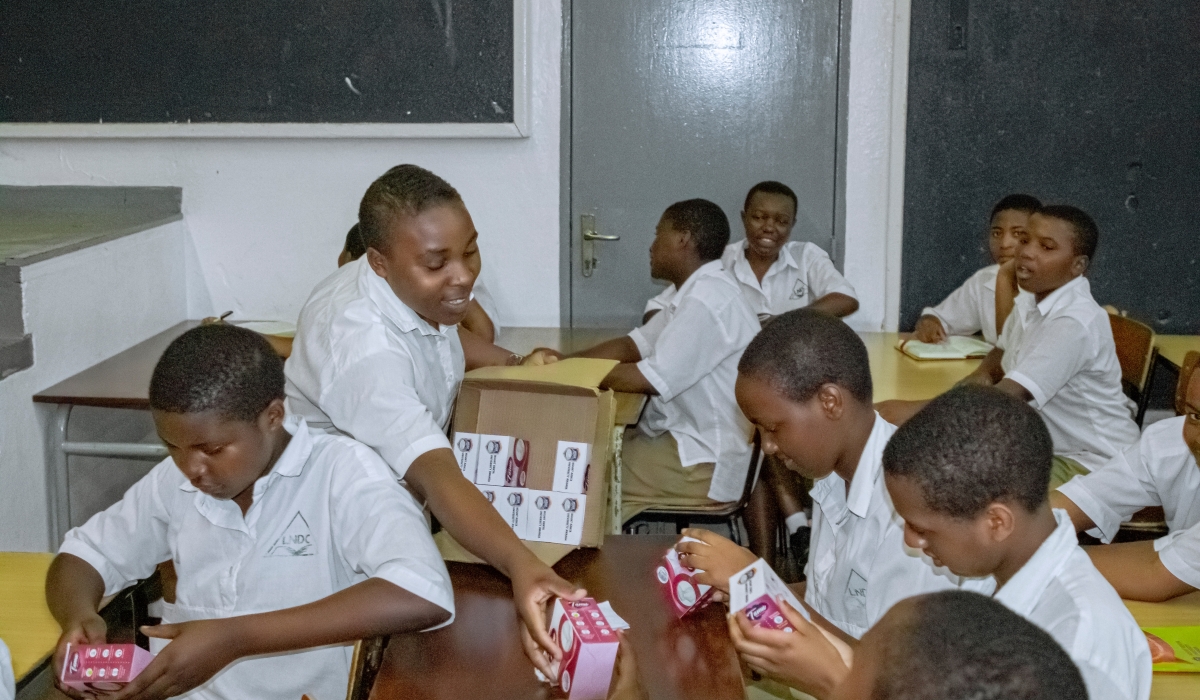 Students receiving sanitary pads donated to them by MKU-Rwanda.