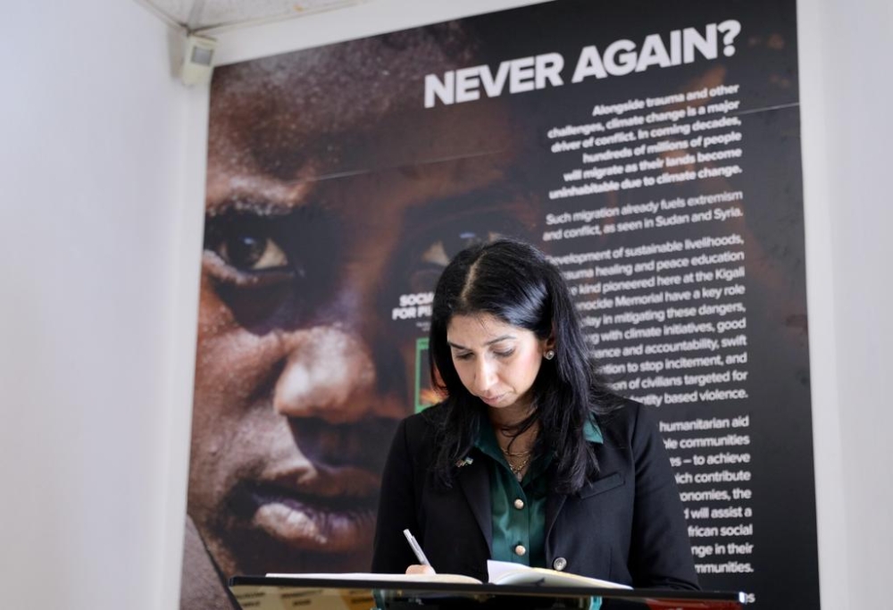 UK Home Secretary Suella Braverman writing in the visitors book at the Kigali Genocide Memorial.