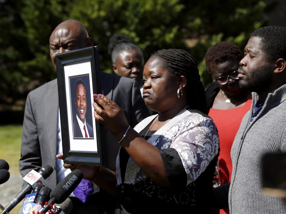Caroline Ouko holds a portrait of her son, Irvo Otieno, as attorney Ben Crump (left) and her older son, Leon Ochieng (right) look on at the Dinwiddie Courthouse in Dinwiddie, Va., on Thursday. Photo: Daniel Sangjib Min/AP