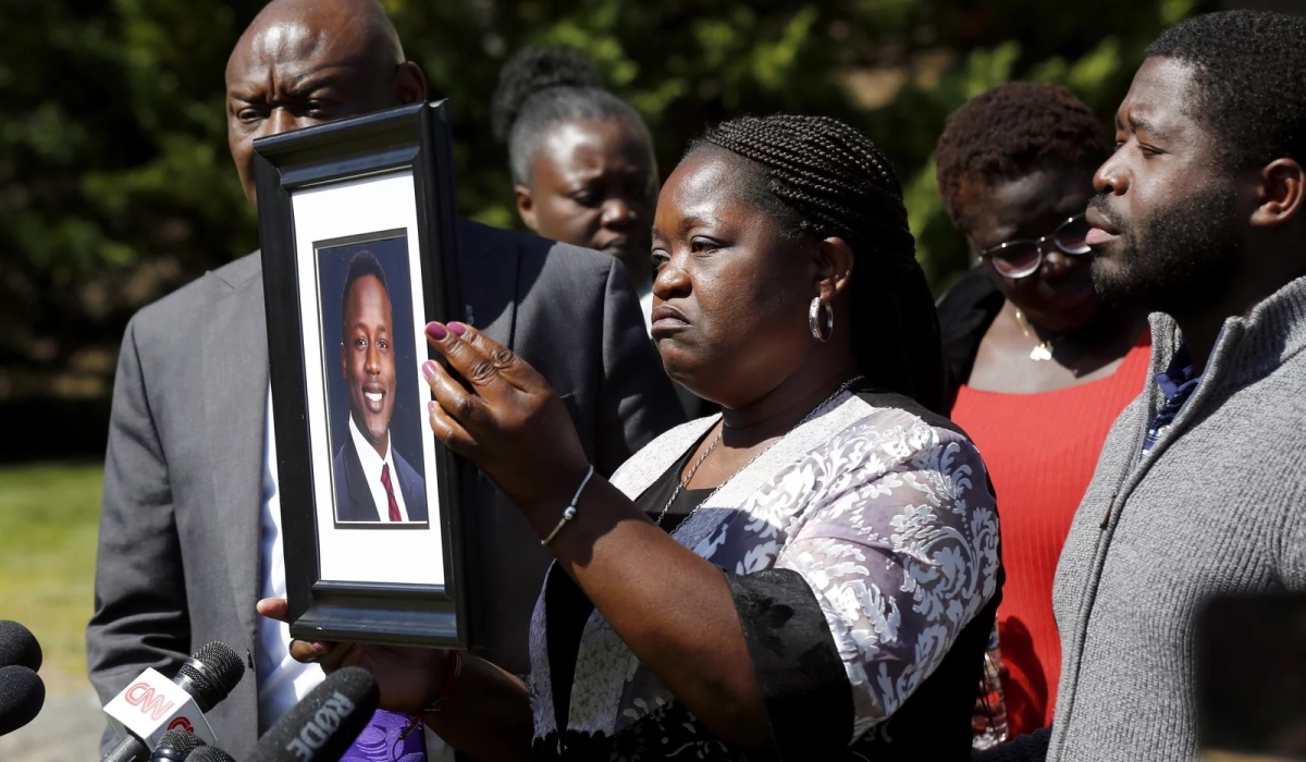 Caroline Ouko holds a portrait of her son, Irvo Otieno, as attorney Ben Crump (left) and her older son, Leon Ochieng (right) look on at the Dinwiddie Courthouse in Dinwiddie, Va., on Thursday. Photo: Daniel Sangjib Min/AP