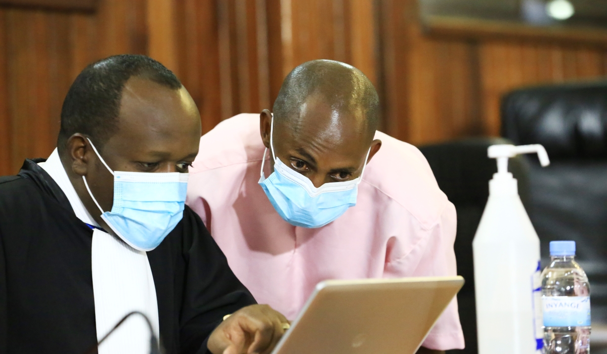 Terror Convict Callixte Nsabimana a.k.a Sankara consults with his lawyer Moise Nkundabarashi during a hearing session  on February 26, 2021. Photo by Sam Ngendahimana