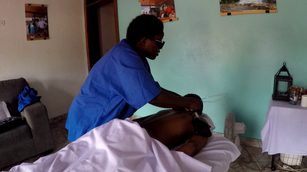 Claudine Uwitije prepares a client before a massage.