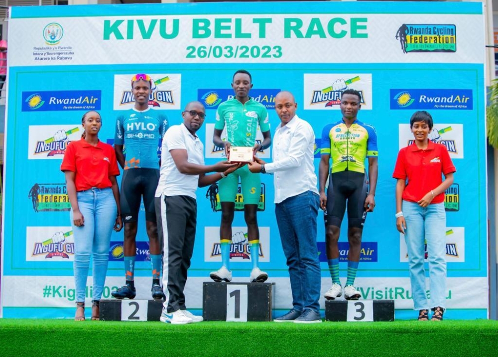 Cycling governing body (Ferwacy) president Abdallah Murenzi (R) and Rubavu Mayor Ildephonse Kambogo (L) present the prize to Kivu Belt race winner Samuel Niyonkuru (C)-courtesy.