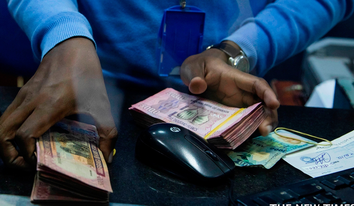 A bank teller counts money while serving customers at Bank of Kigali .The National Bank of Rwanda  announced key economic developments in 2022 through its Monetary Policy Committee and Financial Stability Statement.