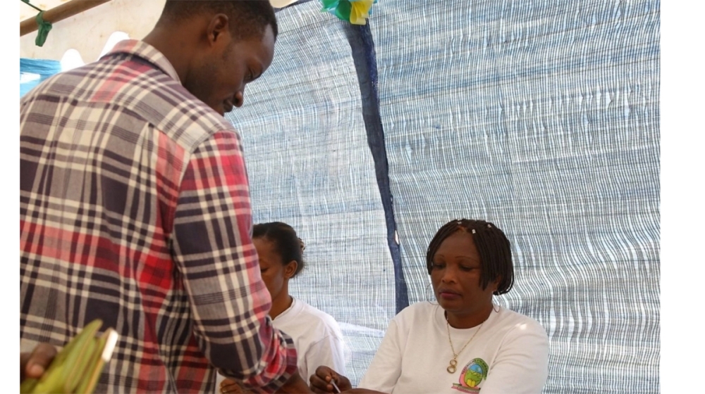 A voter talks to the electoral commission&#039;s volunteers before casting his vote during parliamentary elections in 2018. Sam Ngendahimana

