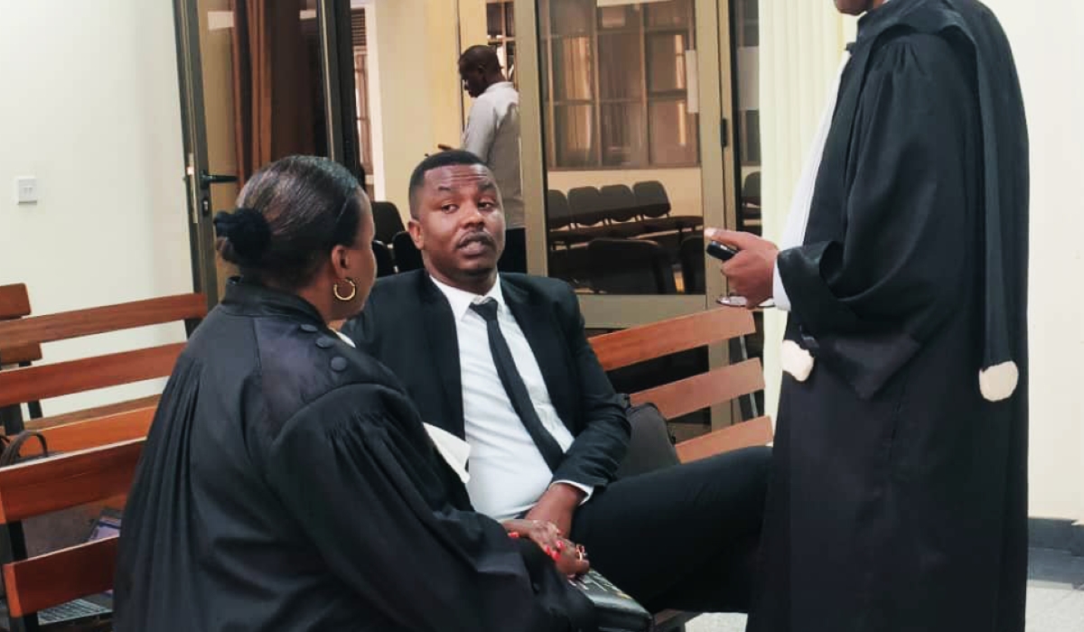 Dieudonne Ishimwe, also known as Prince Kid chats with his lawyers in the High Court in Nyamirambo on Friday, March 31. Courtesy