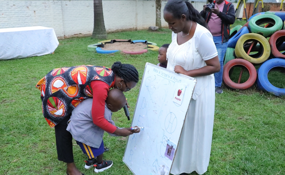 A mother helps her autistic child write on a flip chart at Kigali Autism Centre at Kagugu in Gasabo
District on December 23, 2022. Photo: Craish Bahizi.
