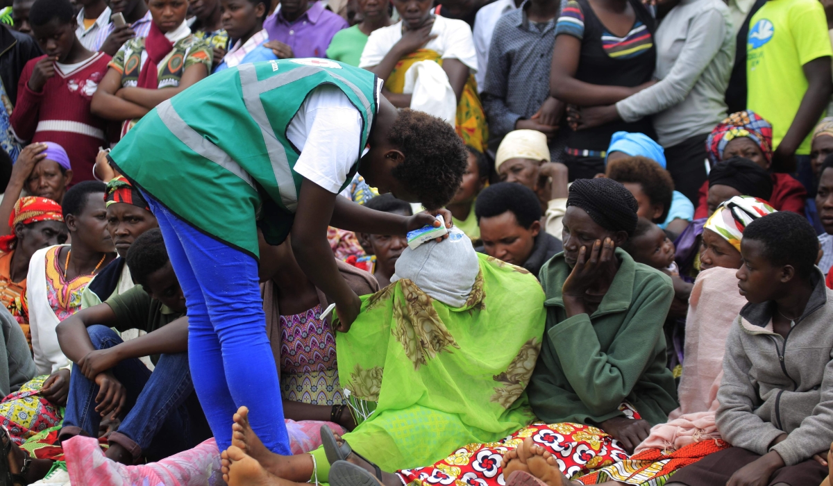 A volunteer tries to help a trauma victim during the commemoration event at Murambi Genocide Memorial. Photo by Sam Ngendahimana