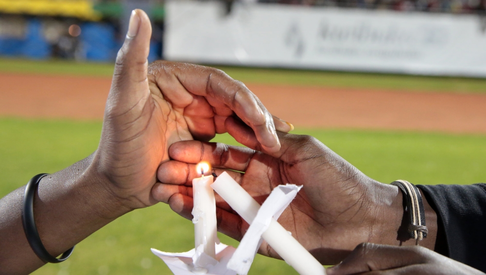 Mourners light a candle during the commemoration of the Genocide Against the Tutsi. File