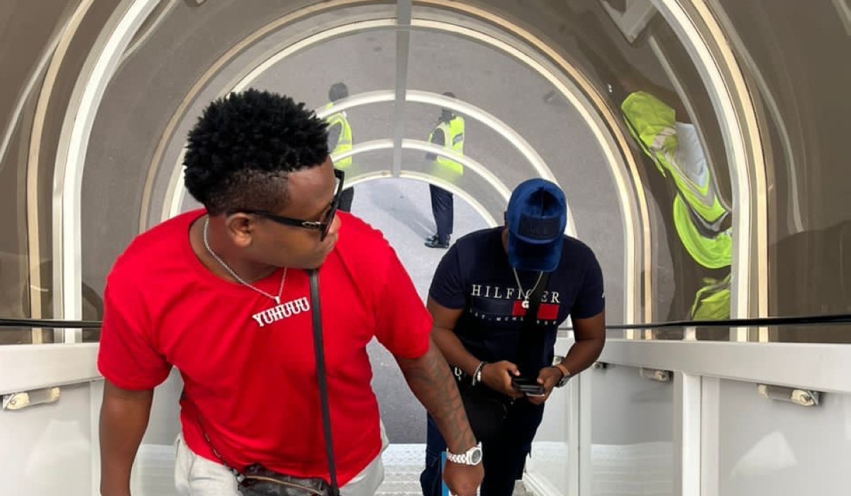 Bruce Melodie and his manager Coach Gael are pictured boarding in at Kigali International Airport ahead of their music tour in Nigeria. Courtesy