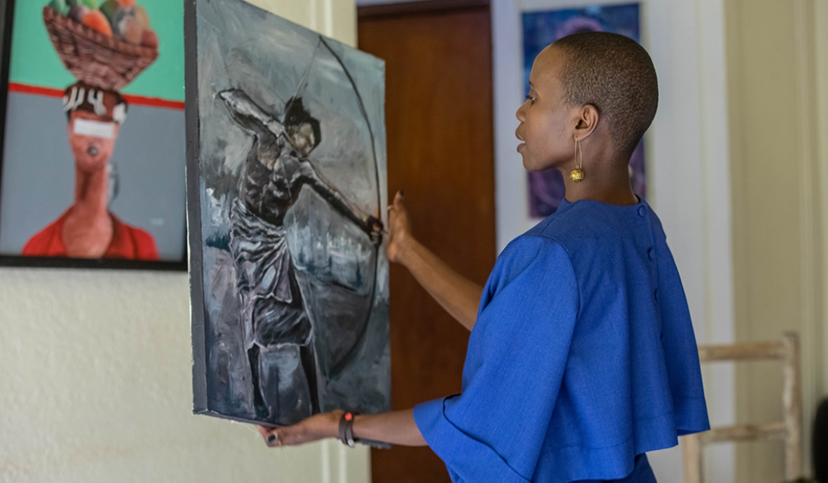 Eliane Umuhire, an actress, viewing artwork during an exhibition in Kigali. Photo by Willy Mucyo